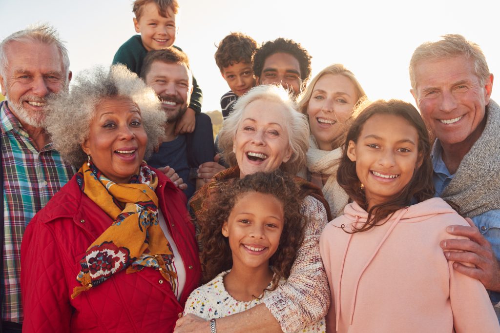 Three generations of a family smiling together outdoors